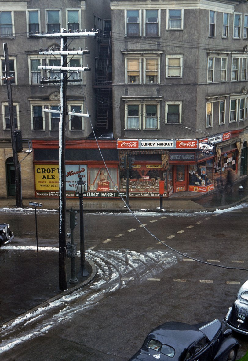 Street corner, Brockton, Massachusetts. January 1941. Two blurry figures pass by a fire hydrant in this time exposure by Jack Delano. View full size. Using the 125 above the door and the street sign as clues, we were able to find this building in Google Maps: 125 Pleasant Street at North Warren Avenue. It's the building to the right with the white roof, and seems to be more or less unchanged. Some of the apartments above the store are on the market as condos. The building the photographer used as his vantage point has disappeared, replaced by a parking lot.