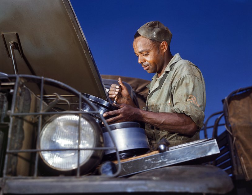 June 1942. Fort Knox, Kentucky. "A good job in the air cleaner of an Army truck. This Negro soldier, who serves as truck driver and mechanic, plays an important part in keeping Army transport fleets in operation." View full size. 4x5 Kodachrome transparency by Alfred Palmer for the Office of War Information.