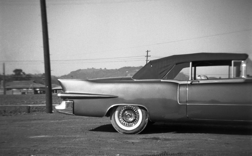 1955 Cadillac Eldorado, photographed in the fall of that year by the nine-year-old me, then at the height of my kidhood car fascination. You can tell the part of the car that fascinated me most by how I aimed the camera. I also talked my brother into taking a Kodachrome slide of it. We were on one of the walks we were wont to take around our home town of Larkspur, California. This shot also captures, at the left, a significant moment in Larkspur history: the building of the first homes in the first major post-war housing development, Hillview Gardens. The houses sold in the low 20Ks. The following year the first kids from there started showing up in my classes at Larkspur-Corte Madera School. View full size.