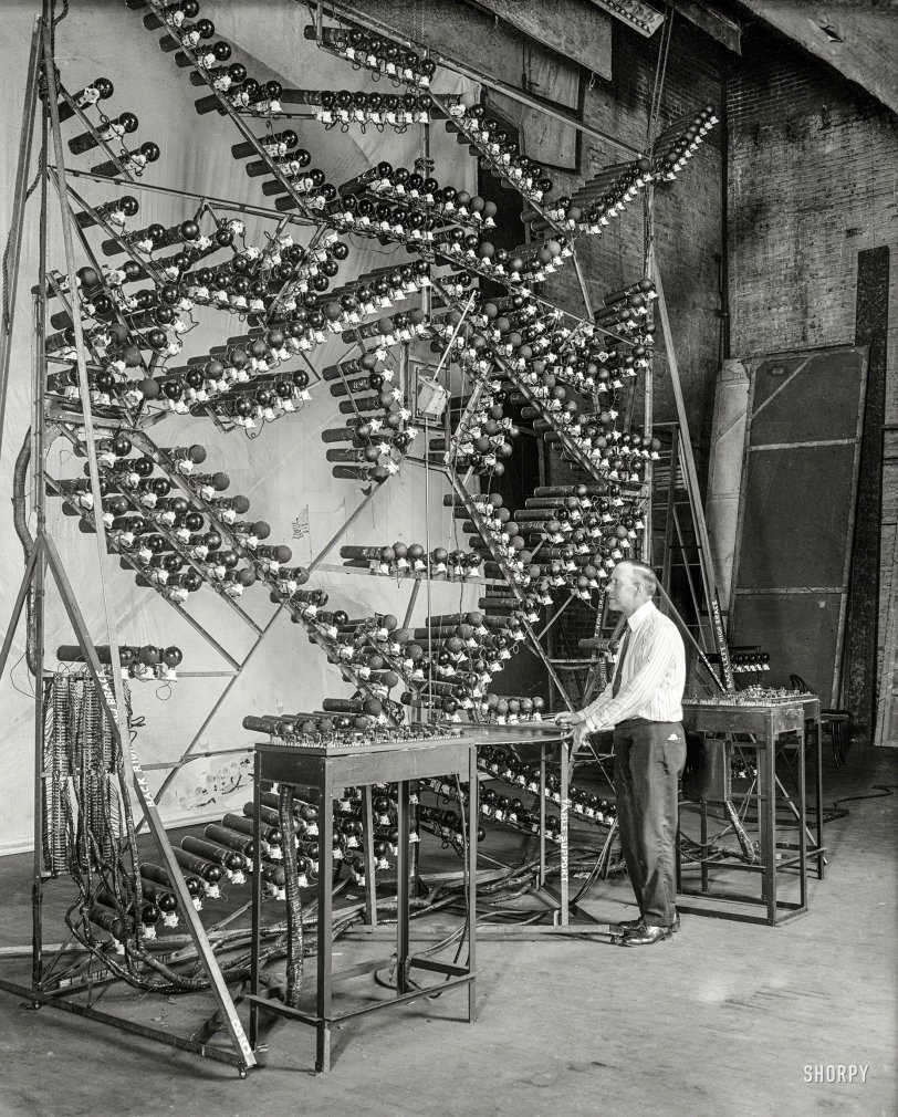 Washington, D.C., 1924. "The latest in electric baseball scoreboards. George Coleman, inventor, is shown with the mechanism of the new scoreboard." Harris & Ewing Collection glass negative. View full size.

&nbsp; &nbsp; &nbsp; &nbsp; A backstage view of Washington, D.C., inventor George Coleman's "Lifelike Baseball Scoreboard" (seen earlier here and here), which was set up in movie theaters to "broadcast" the home team's away games. "It contains 19,000 feet of wire and has 400 stereopticon slides with an electric light bulb for each slide. Five men are required to operate the great board, including the telegraph operator who receives play-by-play from the field." 