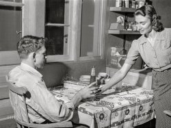 September 1941. "First evening in the new home. FSA defense housing project in  Hartford, Conn. Living in a defense boom town is expensive, so both work -- husband at Pratt & Whitney and wife in a restaurant." Photo by John Collier, Farm Security Administration. View full size.
