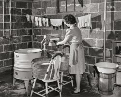 May 1943. "Point Pleasant, West Virginia. Rural life along the Ohio River. Mamie Fergusen Mayme Ferguson, wife of the local junior high school principal, wringing out clothes in the basement." Acetate negative by Arthur Siegel for the Office of War Information. View full size.